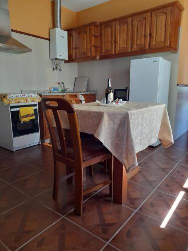 a kitchen with a table with a chair and a refrigerator at Quinta do silva in Celorico de Basto