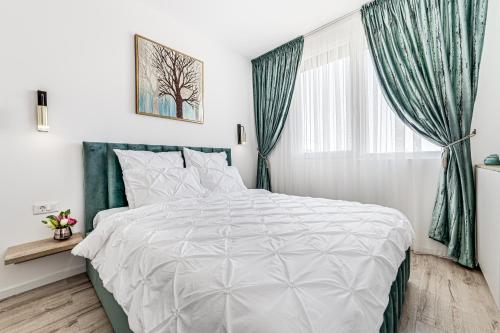 een slaapkamer met een wit bed en een raam bij ARI Turquoise Apartment in ARED in Arad