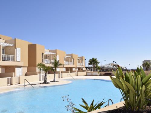 uma piscina em frente a alguns edifícios de apartamentos em PillowAbroad - Dream sea view terrace Duplex em Poris de Abona