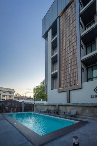 a swimming pool in front of a building at Le Bis Hotel in Chiang Mai