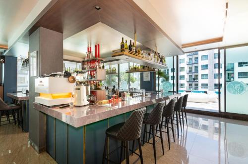 a bar with stools at a restaurant with a view at Rare XXXL Swimming Pools Resort - 500Mbps Blazing Fast Free WIFI - Top Floor Pool View Balcony - Gym - Sauna - Kids Playground - Supermarkets in Pattaya South