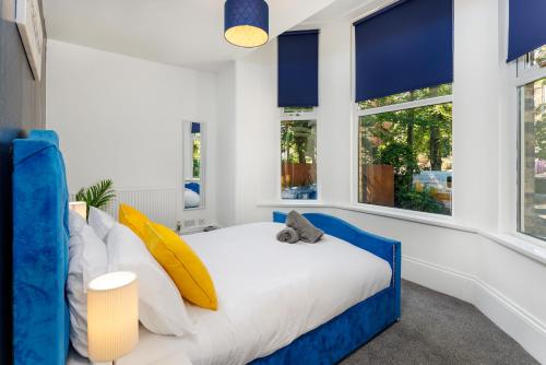 sypialnia z łóżkiem z niebieskimi i żółtymi poduszkami w obiekcie FLATZY - Lovely Sefton Park Retreat w Liverpoolu