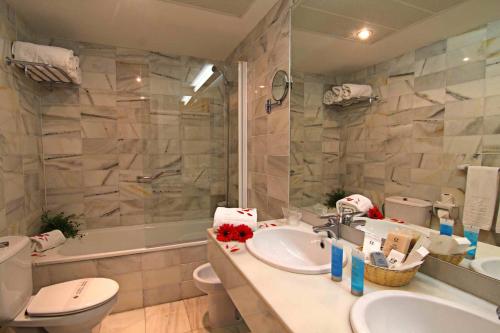 a bathroom with a sink and a toilet and a tub at Hotel San Gil in Seville