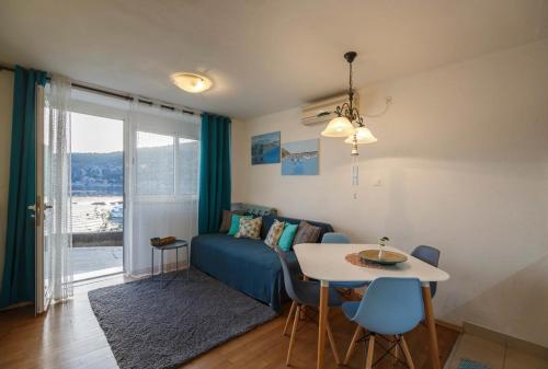 ein Wohnzimmer mit einem blauen Sofa und einem Tisch in der Unterkunft Jurkovica in Komiža