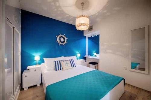 a blue bedroom with a large bed and a blue wall at Jurkovica in Komiža