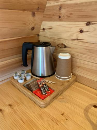 a tea kettle on a tray in a wooden cabin at Glendalough Glamping - Adults Only in Laragh