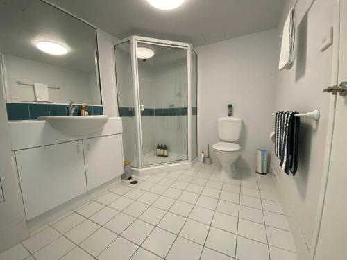 een badkamer met een douche, een wastafel en een toilet bij 2 Bed 2 Bath Apartment in Braddon, Canberra - Pool, Gym and Free Parking in Canberra