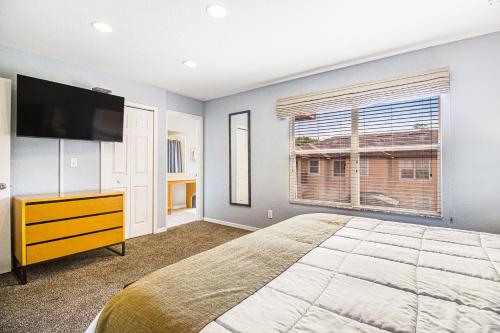 1 dormitorio con 1 cama, TV y ventana en Modern Retreat at Regal Oaks Resort, en Orlando