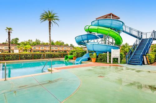 a pool with a water slide in a resort at Modern Retreat at Regal Oaks Resort in Orlando