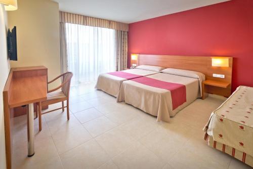 Habitación de hotel con cama grande y escritorio. en Hotel Montemar Maritim, en Santa Susanna