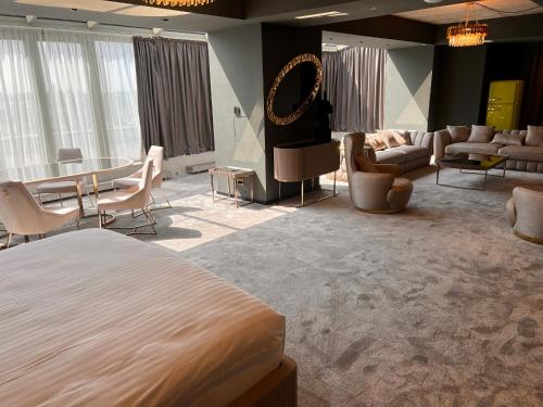 a bedroom with a bed and a living room with furniture at Mercure Timisoara in Timişoara