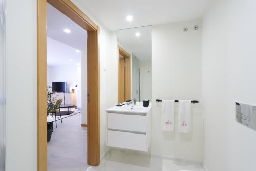 a white bathroom with a sink and a mirror at HM - ISSY Oporto Apartment in Porto