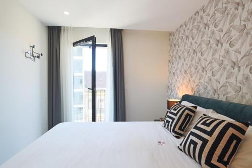 a bedroom with a large white bed with a window at HM - ISSY Oporto Apartment in Porto