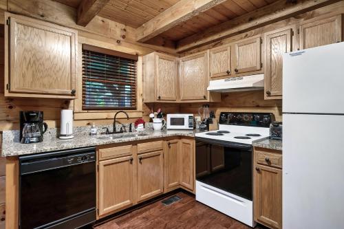 a kitchen with wooden cabinets and a white refrigerator at Beary Patch Hill Hot Tub 9 Miles to Great Smoky Mtn National Park in Sevierville