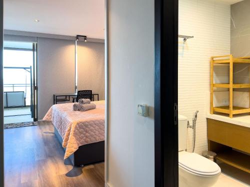 ein Schlafzimmer mit einem Bett und ein Badezimmer mit einem WC in der Unterkunft Luxo e Vista Mar Maravilhosa na Barra da Tijuca B11-0013 in Rio de Janeiro