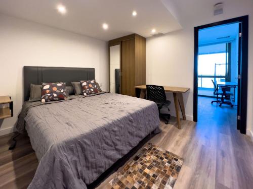 1 dormitorio con cama, escritorio y mesa en Luxo e Vista Mar Maravilhosa na Barra da Tijuca B11-0013, en Río de Janeiro