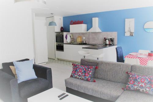 サン・ドニにあるLogement familial tout équipé (1 station de Paris)のソファとキッチンのあるリビングルーム