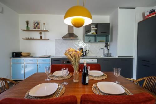 uma cozinha com uma mesa de madeira com pratos e copos de vinho em The Azalea beautiful quiet apartment for 4 people! em Doussard