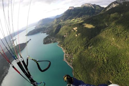 a person flying a parachute over a lake at The Azalea beautiful quiet apartment for 4 people! in Doussard