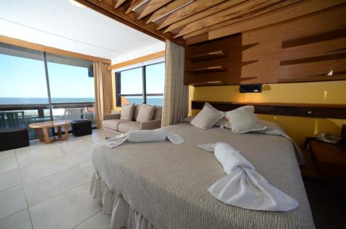 1 dormitorio con 1 cama grande y toallas blancas. en Hosteria Tequendama Classic & Resort en Villa Gesell