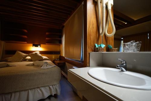 baño con lavabo y cama en Hosteria Tequendama Classic & Resort en Villa Gesell
