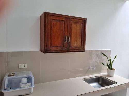 un bancone della cucina con lavandino e mobile in legno di Simply Ur Home in Lucena a Lucena