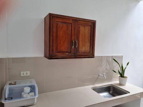 encimera de cocina con fregadero y armario de madera en Simply Ur Home in Lucena, en Lucena