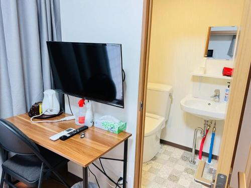 a room with a television on a table with a bathroom at 福宿 Fukuinn 201号室 in Takamatsu