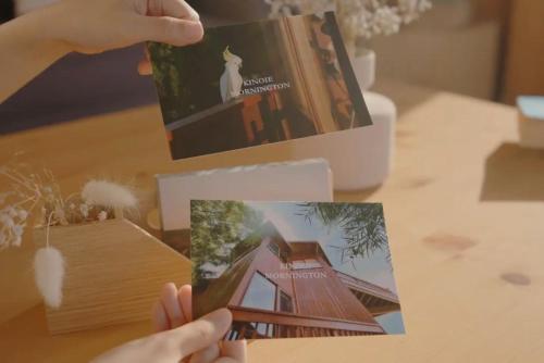 a person holding up a picture of a house on a table at Kinoie Mornington - OCEANVIEW in Mount Martha