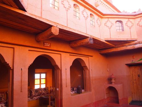 a building with wooden beams on the side of it at Casbah d'hôte La Jeanne Tourisme Ecologique in Boumalne