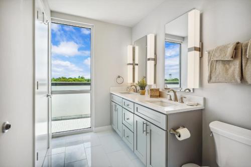 baño con lavabo y ducha con ventana en NOLA Panoramic Penthouse, en Nueva Orleans