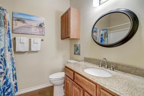 a bathroom with a sink and a toilet and a mirror at Marquesas #310 in Padre Island