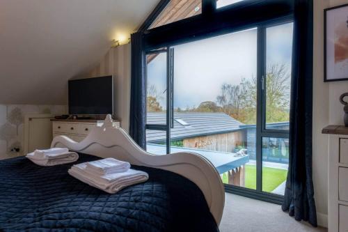 a bedroom with a bed and a large window at Deer Lodge in Lymington