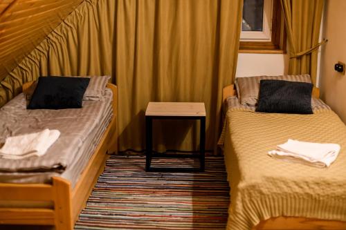a small room with two beds and a table at Ozon Gudauri in Gudauri
