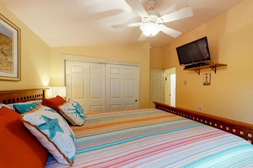 a bedroom with a bed with a ceiling fan and a flat screen tv at Gray Whale Cove MCA 935 in Manzanita