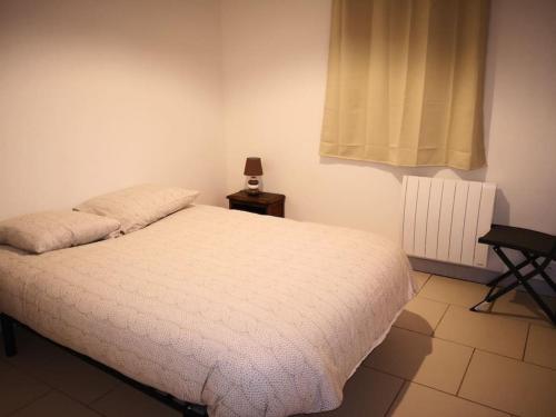 a bedroom with a white bed and a window at L'écurie in Chanceaux-sur-Choisille