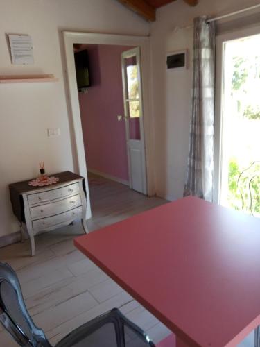 a dining room with a red table and a dresser at Notte Rosa Suites & Relax in Fornovo di Taro