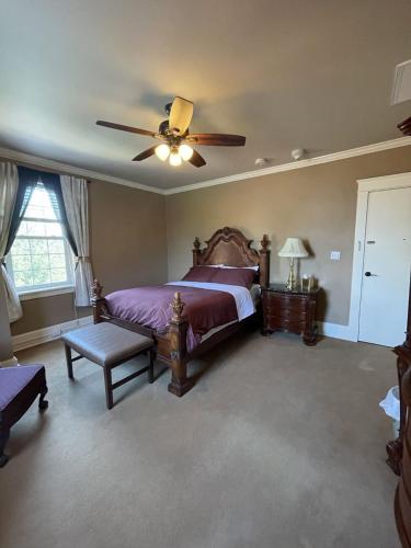 Schlafzimmer mit einem Bett und einem Deckenventilator in der Unterkunft The Woodford Inn in Versailles