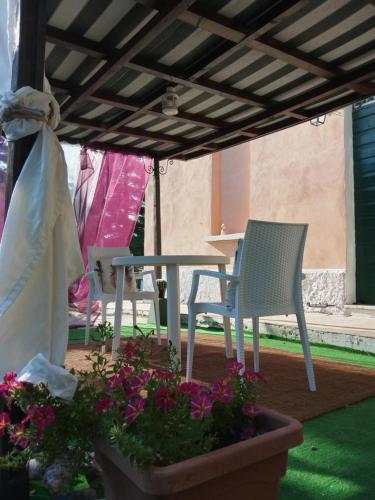 a patio with a table and chairs and flowers at Notte Rosa Suites & Relax in Fornovo di Taro
