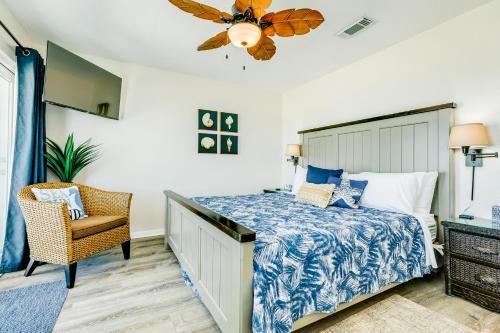 um quarto com uma cama e uma cadeira e uma ventoinha de tecto em Salty Sandpiper em Galveston