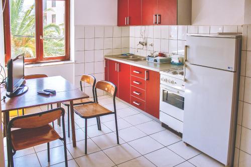 cocina con mesa y nevera blanca en Vera Apartments, en Budva