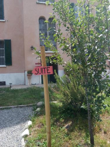 a sign on a pole in front of a tree at Notte Rosa Suites & Relax in Fornovo di Taro