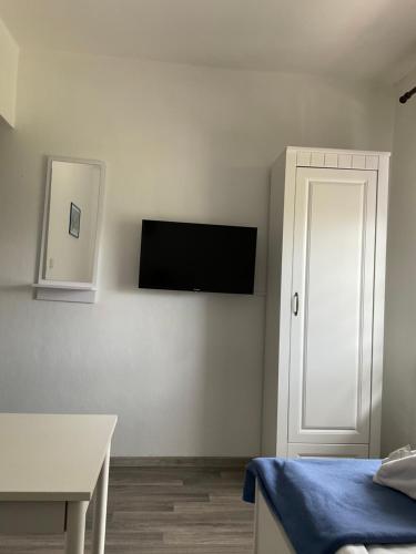 a room with a bed and a tv on a wall at Wellness penzion Harmonie Rohanov in Prachatice