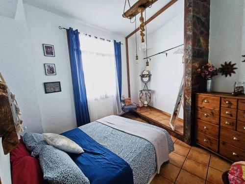 een slaapkamer met een bed, een dressoir en een raam bij La Casita del acantilado in Puerto de la Madera