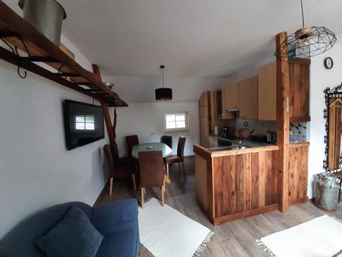 a kitchen and living room with a blue couch and a table at Ferienwohnung Holzer in Payerbach