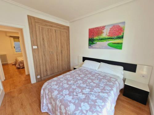sypialnia z łóżkiem i obrazem na ścianie w obiekcie Chabós Jardín del Posío w mieście Ourense
