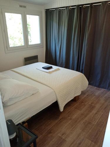 - une chambre avec un lit et un livre dans l'établissement Chalet Agréable, à proximité du centre historique, Golf Academy, à Villeneuve-lès-Avignon