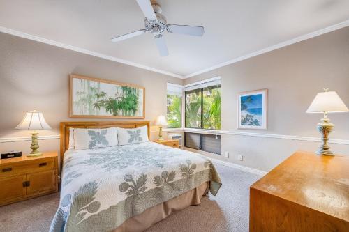 a bedroom with a bed and two lamps and a window at Wailea Grand Champions 58 in Wailea