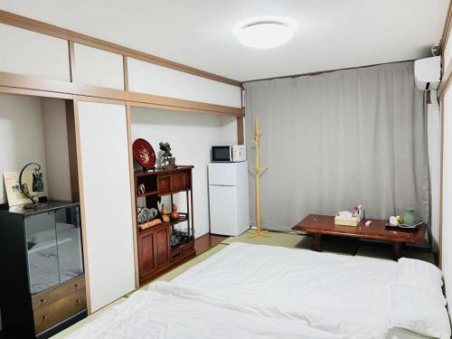 高松市にある福宿 Fukuinn 102号室の白いベッドと机のある寝室
