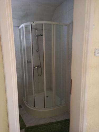 La salle de bains est pourvue d'une douche avec une porte en verre. dans l'établissement Adventure Land, à Jablanica